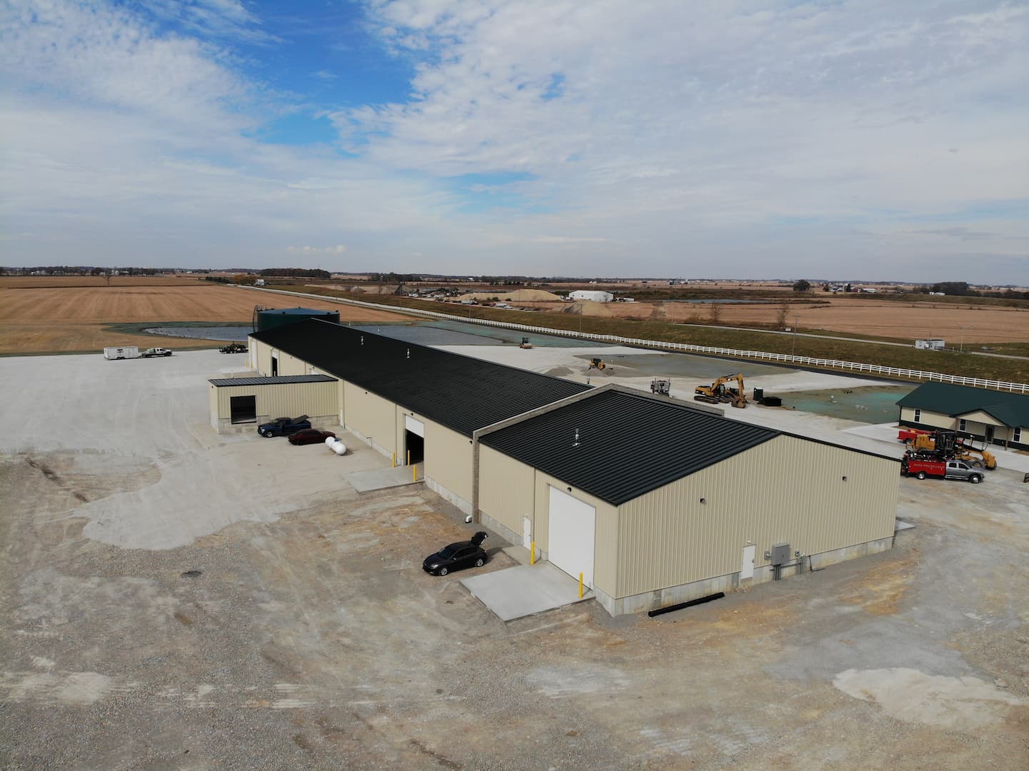 Aerial view of a large metal building complex beside open fields